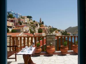 a table on a balcony with a view at Athina Studios in Symi