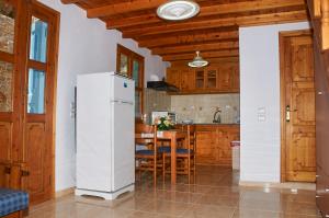 a kitchen with a refrigerator and a table with chairs at Athina Studios in Symi