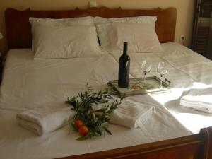 a bed with a tray with a bottle of wine and glasses at La Casa Sul Mare in Paleo Tsifliki