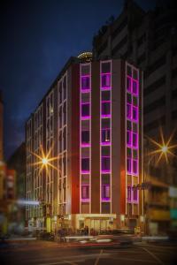 een gebouw met roze lichten aan de zijkant bij Beauty Hotels Taipei - B7 Journey in Taipei