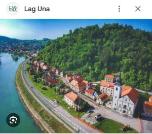 a small town on a hill next to the water at Camping Nori-Una in Hrvatska Kostajnica