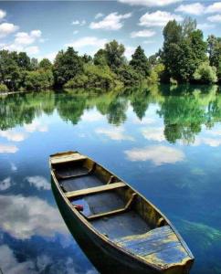 a wooden boat sitting in the middle of a lake at Camping Nori-Una in Hrvatska Kostajnica +12 photos
