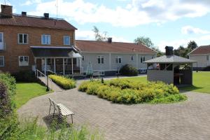 a building with a bench in the middle of a courtyard at Brålanda Hotell och Vandrarhem in Brålanda
