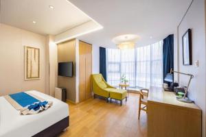 a hotel room with a bed and a desk and a chair at Yitel Shenyang Sanhao Street Shengjing Hospital in Shenyang