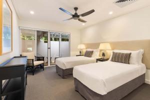 a bedroom with two beds and a desk with a piano at Mirage Resort Villa 422 with access to Sheraton Facilities in Port Douglas