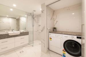 a bathroom with a washer and a sink and a washing machine at Mirage Resort Villa 422 with access to Sheraton Facilities in Port Douglas