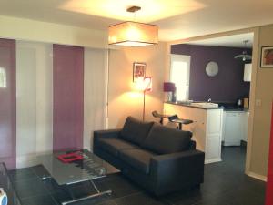 a living room with a couch and a table at Duplex proche plage et centre ville in Concarneau