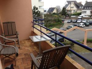 a balcony with two chairs and a table and a street at Duplex proche plage et centre ville in Concarneau