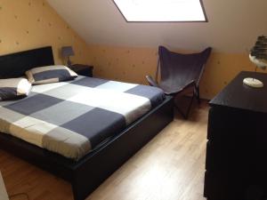 a bedroom with a bed and a chair in it at Duplex proche plage et centre ville in Concarneau