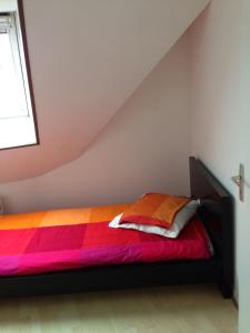 a bedroom with a bed with a colorful blanket at Duplex proche plage et centre ville in Concarneau +3 photos