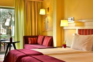 a hotel room with two beds and a couch at Pestana Sintra Golf Resort & SPA Hotel in Sintra