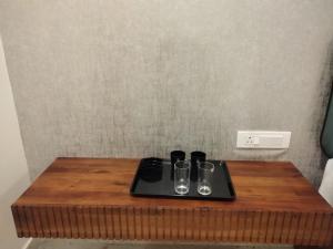 a wooden table with glasses on top of it at Alpine Cloud Resort in Yercaud +17 photos