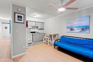 a living room with a blue couch and a kitchen at Shore Oasis in Seaside Heights