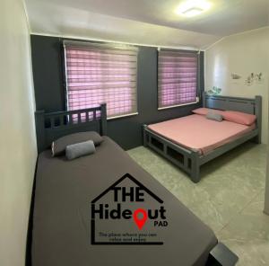 a bedroom with two beds and a sign that reads the hideout pad at The Hideout Pad in Anunas