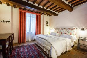 a bedroom with a bed and a desk and a window at Villa Acquaviva Wine Resort in Montemerano +110 photos