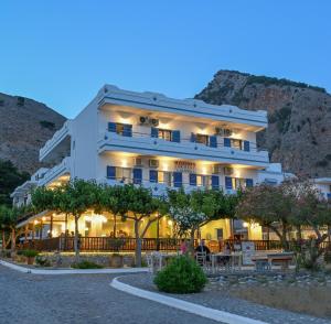 a hotel on the side of a mountain at night at Calypso in Agia Roumeli