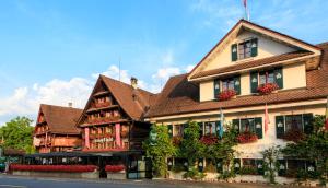 a large building with flowers in front of it at Swiss-Chalet Merlischachen - Historik Chalet-Hotel Lodge in Küssnacht