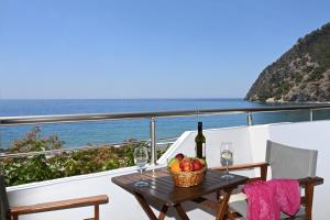 a table with a basket of fruit and a bottle of wine at Calypso in Agia Roumeli