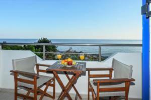 a table with two chairs and a bowl of fruit on a balcony at Calypso in Agia Roumeli