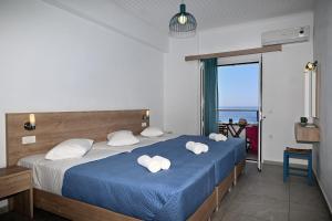 a bedroom with a bed with towels on it at Calypso in Agia Roumeli
