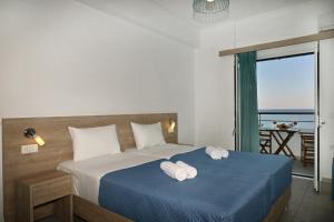 a bedroom with a bed with towels on it at Calypso in Agia Roumeli