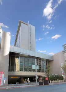 um grande edifício numa rua com um céu azul em Urawa Washington Hotel em Saitama