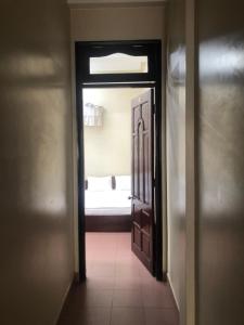 Un pasillo con una puerta abierta con una cama al fondo. en Bảo Thịnh, en Da Lat