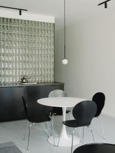 Un comedor con una mesa y sillas blancas. en NOOK Stay am Checkpoint Charlie, en Berlín