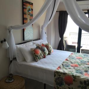 a bedroom with a bed with a canopy and a window at Apartments Seaside Baosici in Herceg-Novi