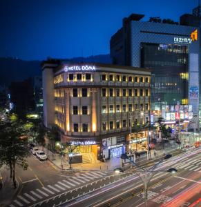 a lit up building on a city street at night at Hotel Doma Myeongdong in Seoul