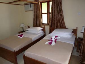 2 Betten in einem Zimmer mit Blumen darauf in der Unterkunft Pemba Misali Sunset Beach in Wesha