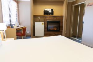 a hotel room with a bed and a fireplace at The Man from Snowy River Hotel in Perisher Valley