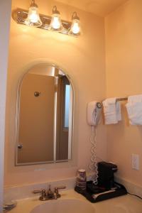 La salle de bains est pourvue d'un lavabo avec miroir et d'un sèche-cheveux. dans l'établissement Budget Inn, à San Luis Obispo