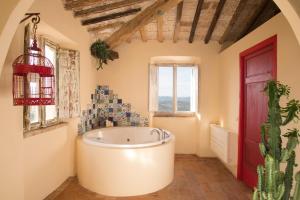 a bathroom with a large tub in a room with a window at B&B La Pecora Nera in Mazzolla