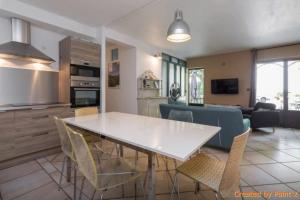 uma cozinha e sala de estar com uma mesa branca e cadeiras em Auberge la Tuilerie em Violès