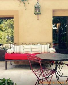 a couch on a patio with a table and chairs at Auberge la Tuilerie in Violès