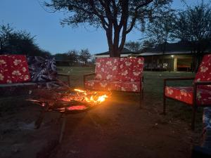 duas cadeiras e uma fogueira em um quintal à noite em Zuhumath Tented Camps Serengeti em Parque Nacional Serengeti