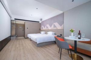 une chambre avec un grand lit et une table et des chaises dans l'établissement Borrman Hotel Yongzhou Lingling Ancient Town Government, à Guzhuting 188 autres photos