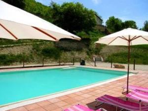 a swimming pool with two umbrellas and two chairs at APPARTAMENTI Villa Marianna in Spoleto