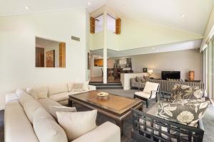a living room with a couch and a table at Mirage Resort Villa 112 with access to Sheraton Facilities in Port Douglas