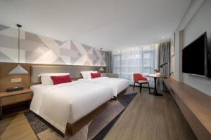 a hotel room with two beds and a flat screen tv at Borrman Hotel Guilin Two Rivers and Four Lakes Beiji Plaza in Guilin