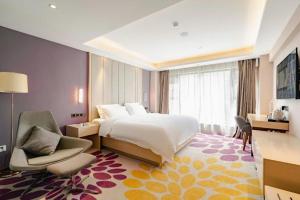 a bedroom with a bed and a chair and a desk at Lavande Hotel Wuhan Houhu Avenue Xingye Road in Wuhan