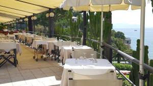 a restaurant with white tables and chairs on a balcony at Hotel Continental in Santa Margherita Ligure