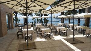 a patio area with tables, chairs and umbrellas at Hotel Continental in Santa Margherita Ligure