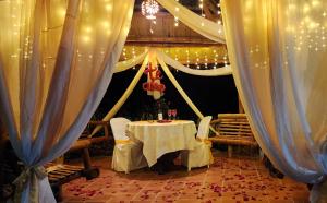 a table in a room with white drapes at Hotel y termales Las Heliconias in Zetaquira +100 photos