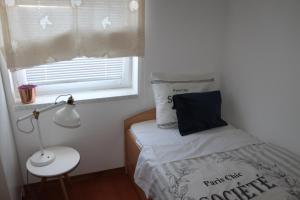 mała sypialnia z łóżkiem i oknem w obiekcie Vili Apartment Quiet leisure in Preko w mieście Preko