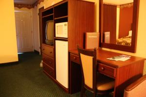 a room with a desk and a computer and a desk and a television at Relax Inn Chehalis in Chehalis
