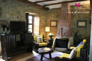 uma sala de estar com um sof, cadeiras e uma televiso em Villa Silene na Covilh