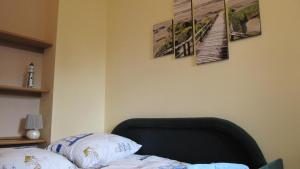 a bedroom with a bed and some pictures on the wall at Apartament Żeglarski in Kołobrzeg