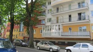 two cars parked in front of a building at Apartament Żeglarski in Kołobrzeg